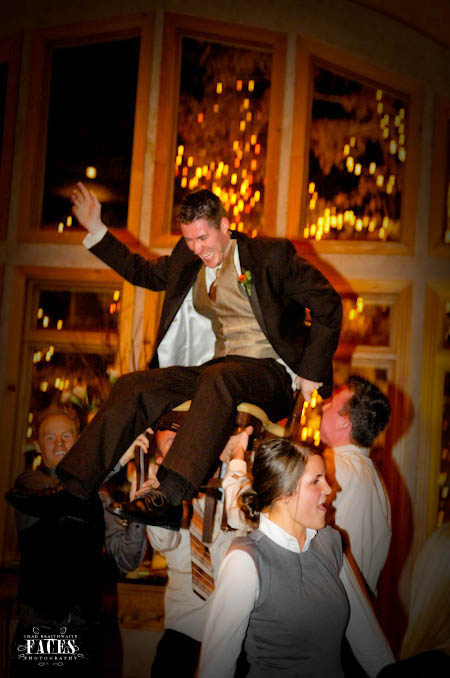 Groom being lifted up into the air on a chair