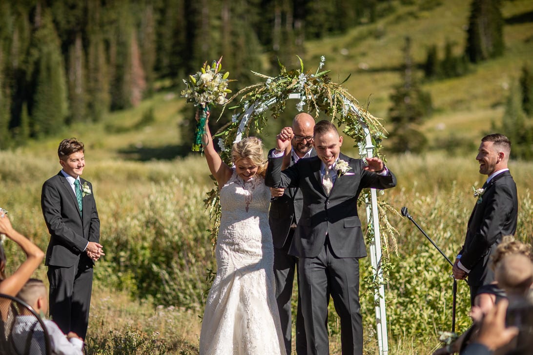 Bride and groom cheering at the altar