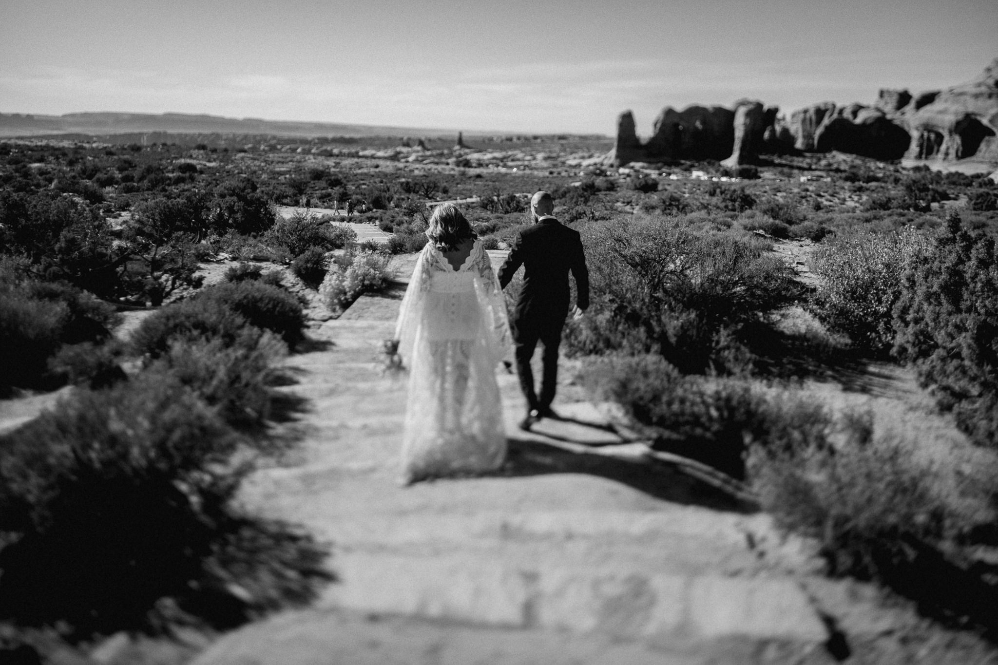 Bride and Groom walking to see double arch