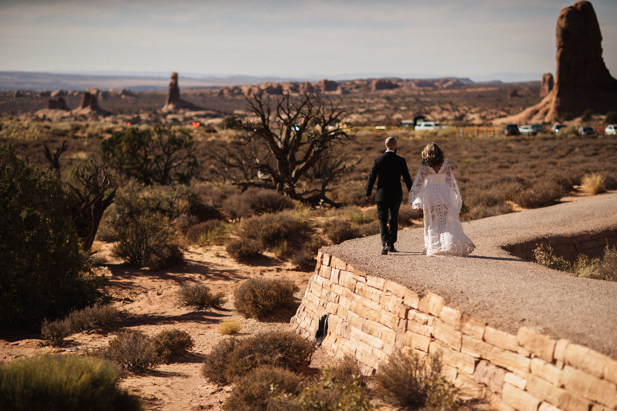 Bride and Groom walking to see double arch