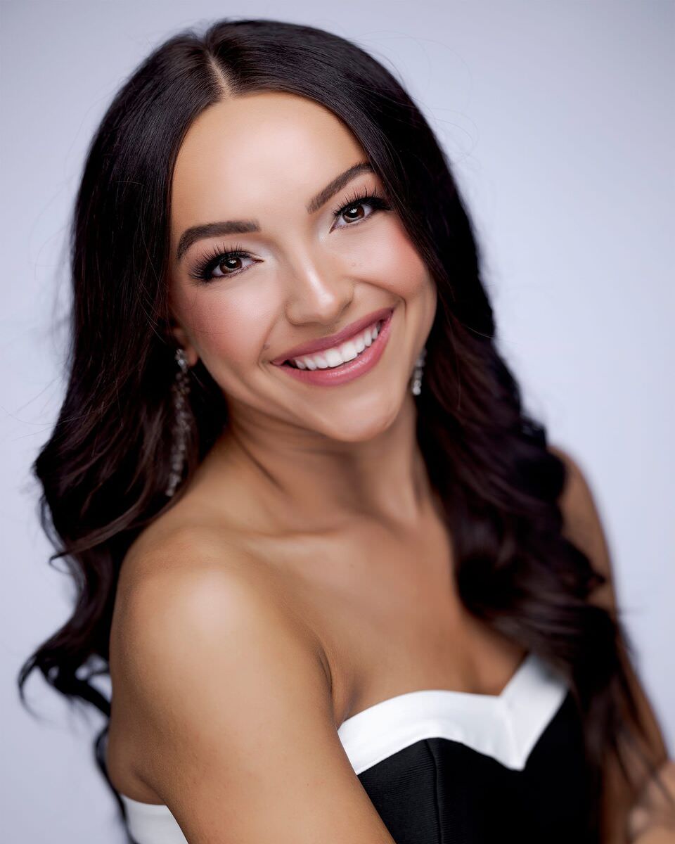 Headshot: long dark waves, black and white neckline