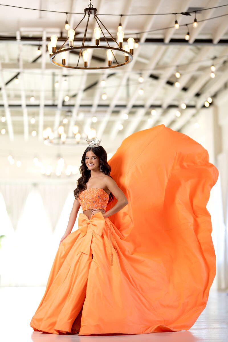 Look three: flowing orange gown under a chandelier