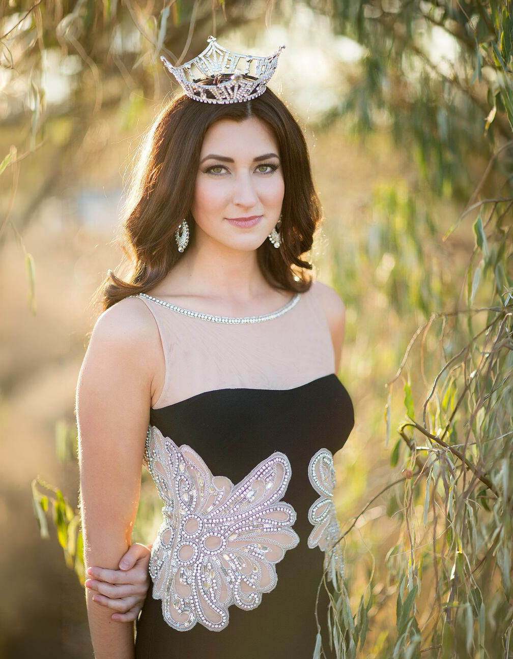 Outdoor: titleholder in crown in a golden sunlit field