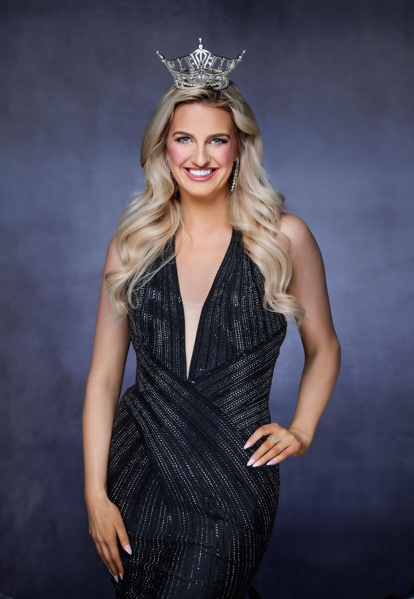 Posed: Miss Utah in crown and black gown, hand on hip